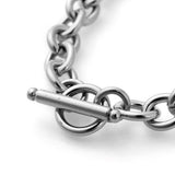 zoomed in toggle clasp on stainless steel cable chain bracelet on a white background. 