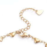 zoomed in golden lobster claw clasp and extender chain with heart charm on white background. 