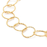 zoomed in section of golden textured large Rolo chain on white background. 