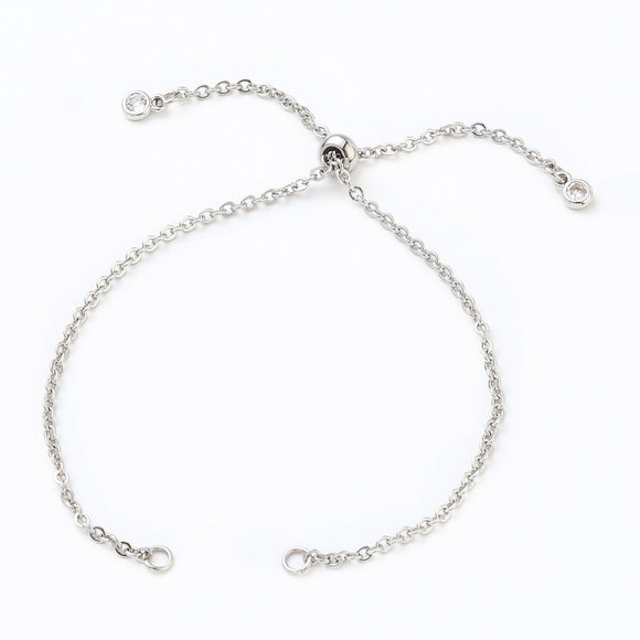 stainless steel bolo style cable chain bracelet making with slider bead and bezel set clear stone stopper beads on white background. 