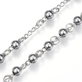 zoomed in section of stainless steel beaded rosary on white background. 