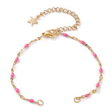 golden link bracelet making with pink enamel, a lobster claw clasp and extender with a star charm on the end on a white background. 