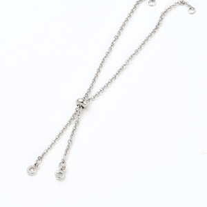 stainless steel bolo style cable chain bracelet making with slider bead and bezel set clear stone stopper beads on white background. 