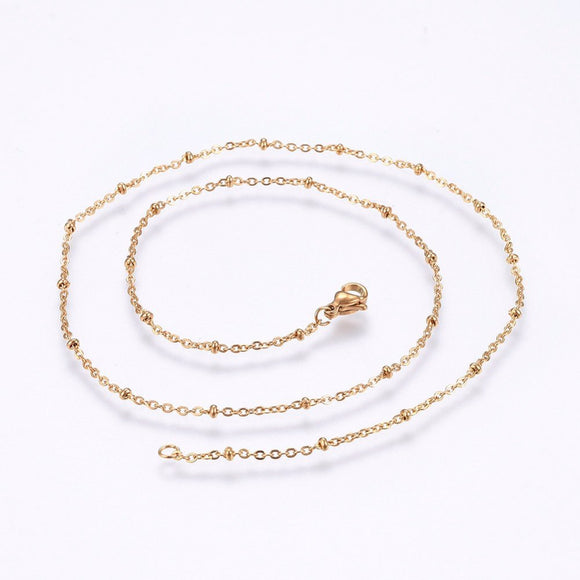 golden satellite cable chain necklace with lobster claw clasp on white background. 