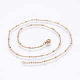 golden satellite cable chain necklace with lobster claw clasp on white background. 