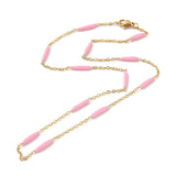 golden curb chain and pink enamel bar link necklace with lobster claw clasp on white background. 