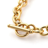 zoomed in toggle clasp on a golden cable chain bracelet on a white background. 