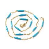 golden curb chain and blue enamel bar link necklace with lobster claw clasp on white background. 